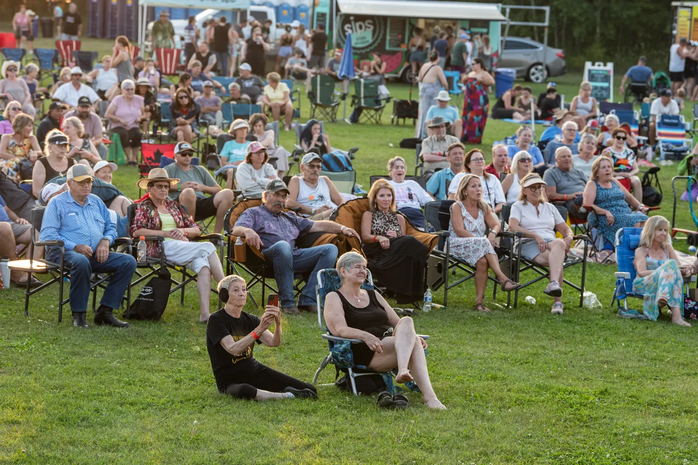 A broad view of festival guests seated across the grass in 2025