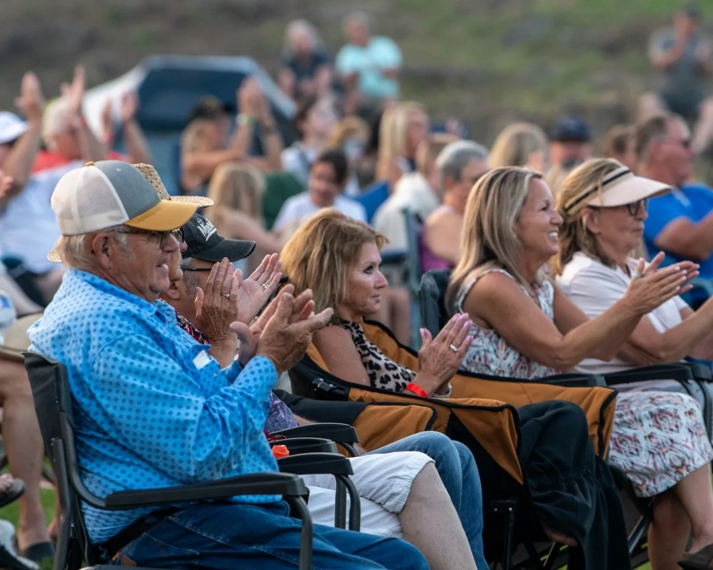 Festival guests applauding from lawn chairs in 2025