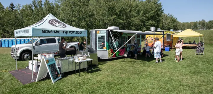 Food vendors and guests lining the edge of the 2025 festival field