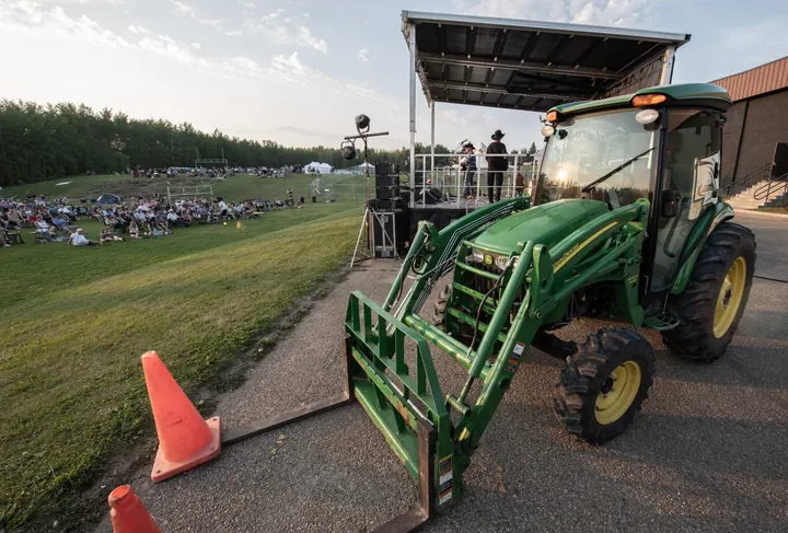 A green tractor displayed on the festival grounds in 2025