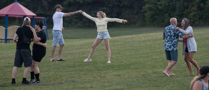 Festival guests dancing together across the field in 2025