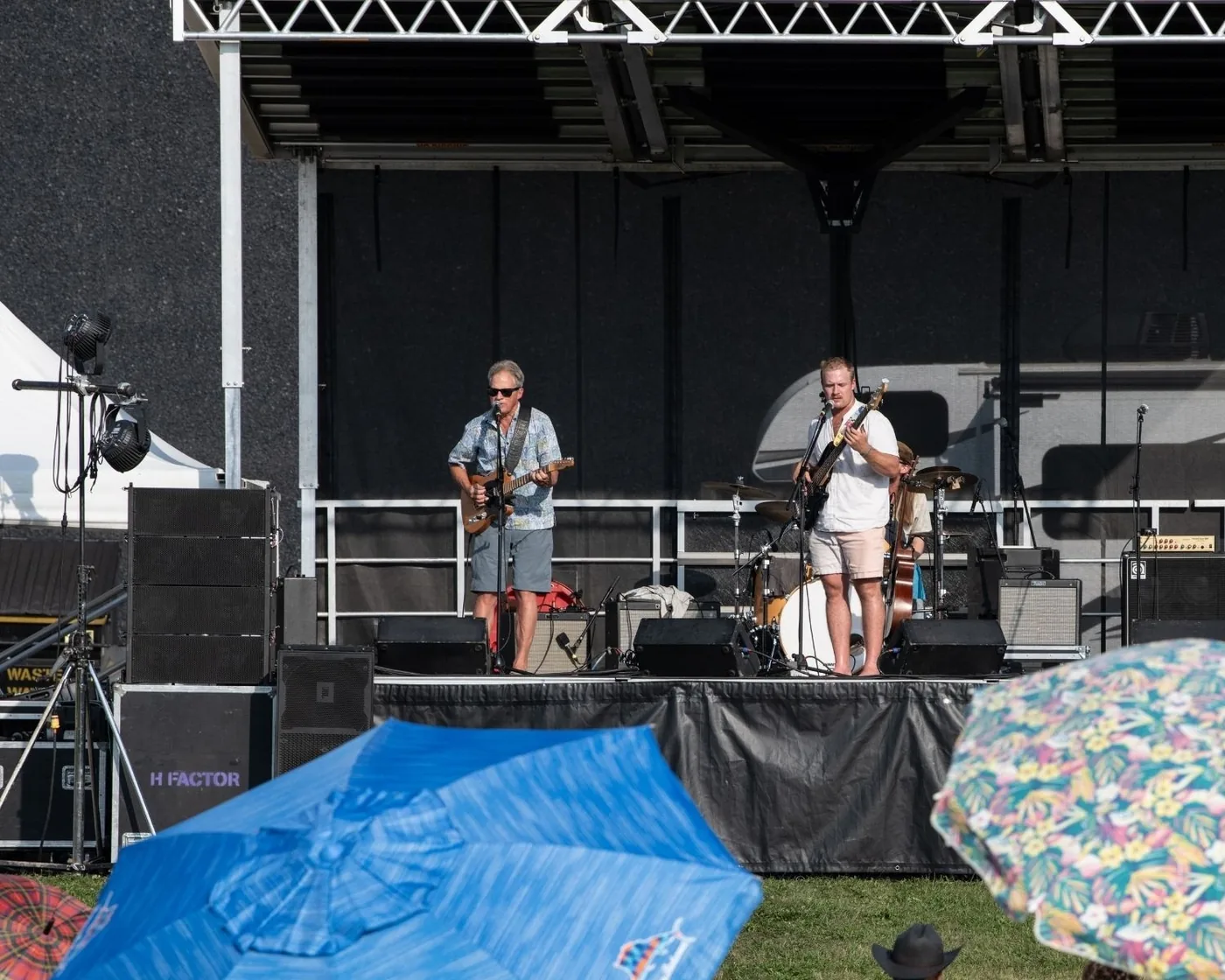 Audience umbrellas facing the outdoor festival stage in 2025