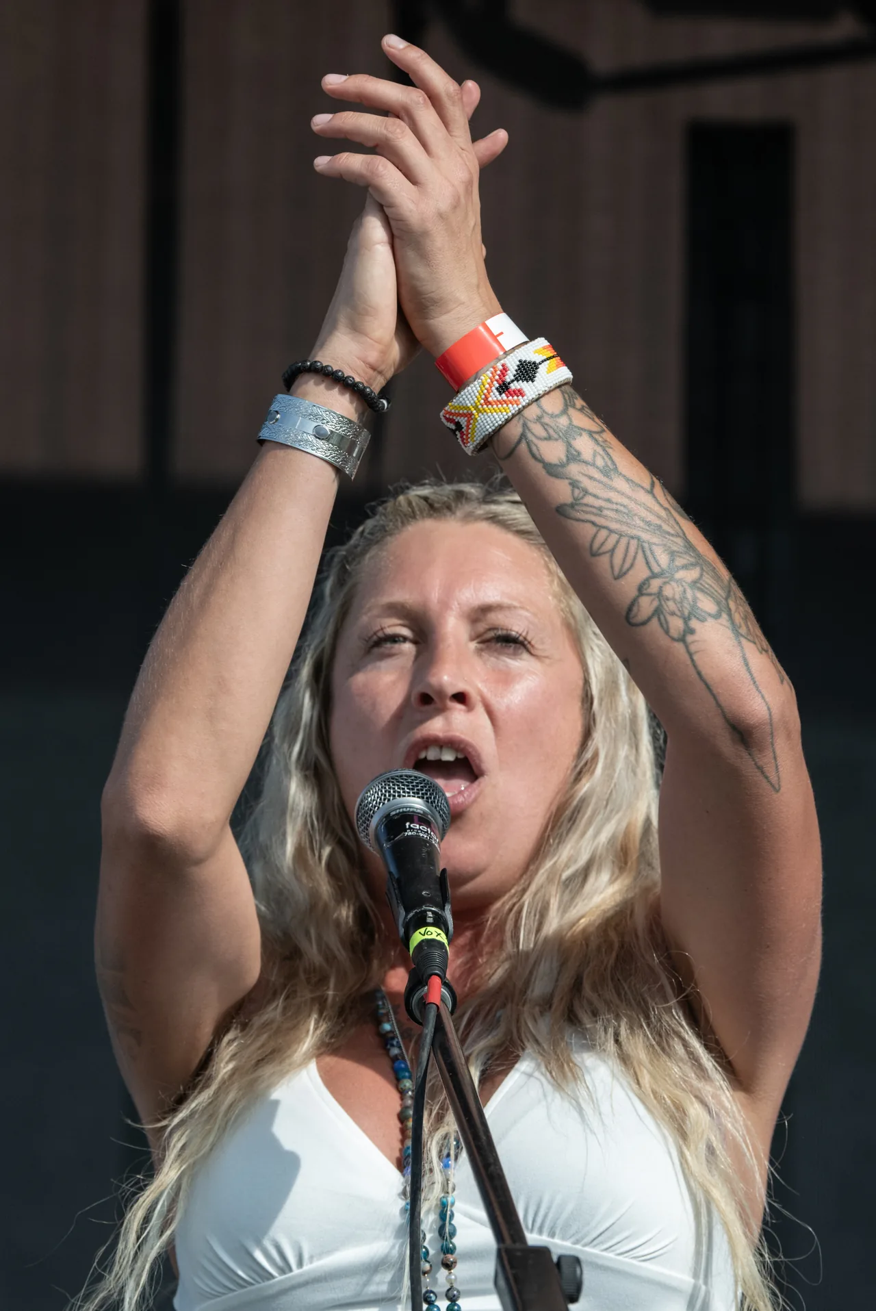 A singer raising both hands during a 2025 stage performance