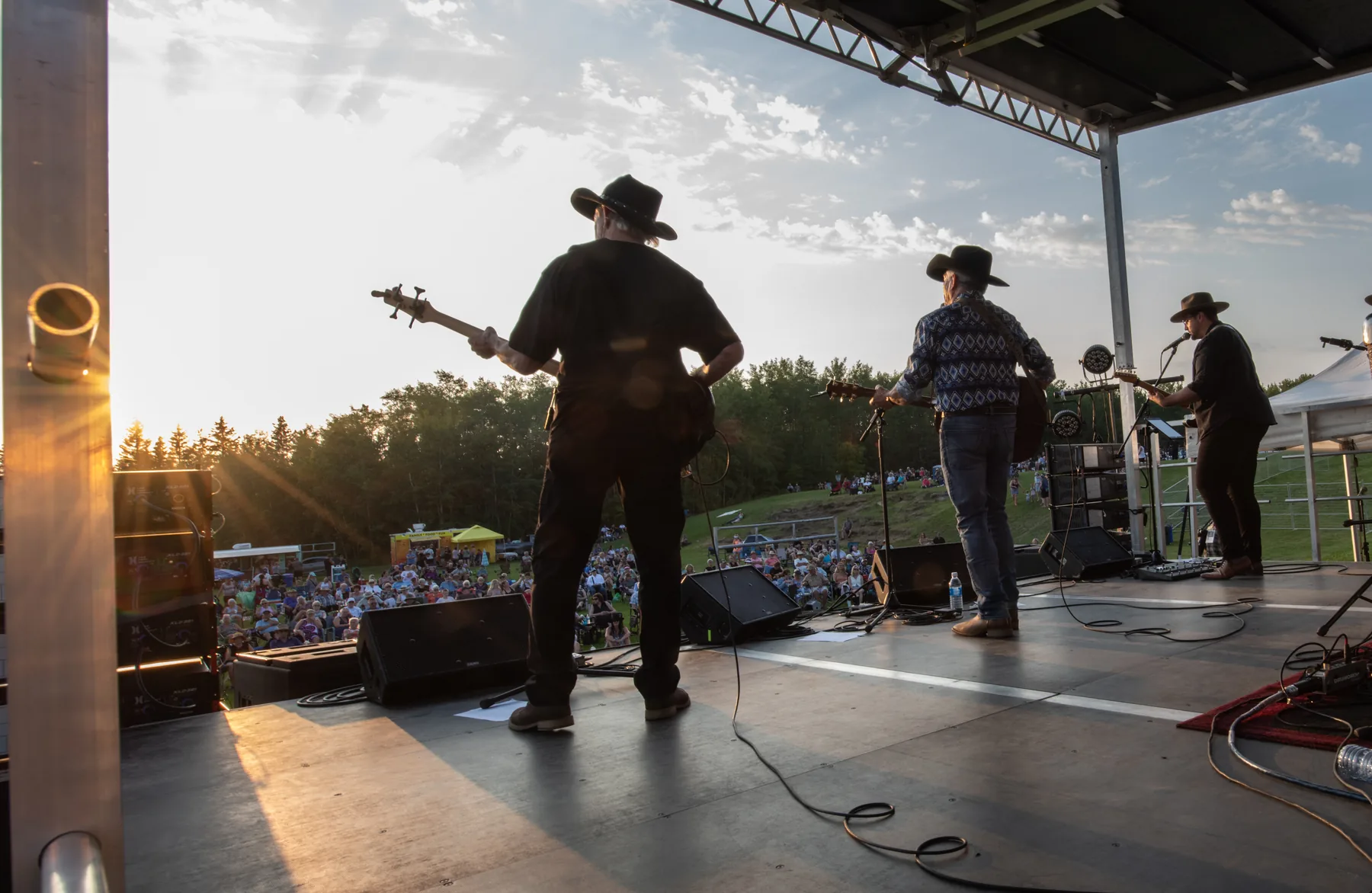 Musicians performing at sunset during the inaugural In the Woods Music Festival